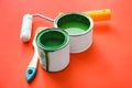 Paint cans with roller and brush on color background Royalty Free Stock Photo