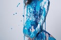 paint drips from the woman body, blue liquid drops on beautiful model girl`s body, creative abstract