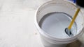 The paint is mixed in a bucket. Water based paint. Mixing water-based paint in a bucket using a construction mixer with