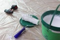 Paint mixer with white paint bucket and roller brush on floor. Royalty Free Stock Photo