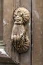 Paint peeling door knocker on worn door of dilapidated house Royalty Free Stock Photo
