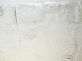 Paint peeling off wall. Cracked, crumbling plaster on the brick wall, White wall Cracked surfaces. Royalty Free Stock Photo