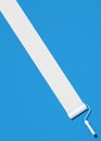 Paint roller brush with a white color trail on blue background