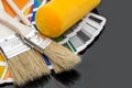 Paint roller and brushes with color swatches book on black reflective background Royalty Free Stock Photo