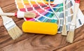 Paint roller and brushes with color swatches book on the table Royalty Free Stock Photo