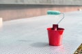 Paint roller and a bucket with paint next to a building exterior wall. Painting house plinth outside. Home renovation. Nobody Royalty Free Stock Photo