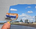 A paint roller of a painter man paint a picture from Bremerhaven on the wall