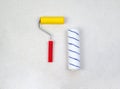 Paint roller with red handle, yellow smooth and soft velou nozzles isolated on light background.