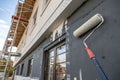 Paint roller on wall during exterior renovation Royalty Free Stock Photo