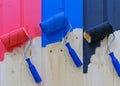 Paint rollers on a wooden wall. Multicolored paint rollers.