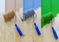 Paint rollers on a wooden wall. Multicolored paint rollers