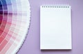 Paint samples, multi colour swatch for interior design. Light lilac background. White paper notebook for drawing or writing. Copy