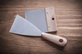 Paint scraper and putty spattle on wood board Royalty Free Stock Photo