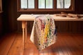 paint-splattered apron folded on wooden table