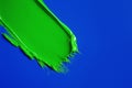 Paint stroke. A brush stroke of thick green paint on a dark blue background Royalty Free Stock Photo