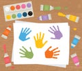 Paint tubes, palette, canvas with colorful handprints. Art therapy. Royalty Free Stock Photo