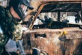 Paintball battle, players fight around burned car Royalty Free Stock Photo