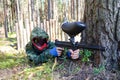 Paintball player behind pine tree aiming