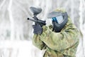 Paintball player with marker at winter outdoors