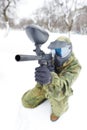 Paintball player with marker at winter outdoors
