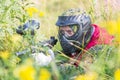 Paintball sport player in protective uniform and mask playing with gun outdoors and sneaking in grass. Royalty Free Stock Photo