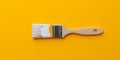 Paintbrush Covered In White Paint Against A Vibrant Yellow Backdrop In Mockup