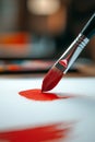 Paintbrush making a precise red stroke on textured white paper in a focused artistic composition Royalty Free Stock Photo