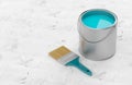 Paintbrush with silver paint bucket with cyan paint on white wooden floor background, home renovation concept with copy space Royalty Free Stock Photo