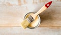 A paintbrush is sitting in a can of paint. The brush is red and white Royalty Free Stock Photo