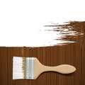 Paintbrush with white paint on a wooden surface.