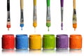 Paintbrushes Dripping into Paint Containers Royalty Free Stock Photo