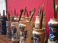 Paintbrushes in Spanish traditional porcelain vases against red wall