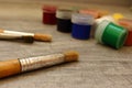 Paintbrushes and unfocused multicolored watercolor paints on grey stone background as drawing concept. Royalty Free Stock Photo