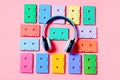 Painted audio cassettes and blue headphones on pink background, copy space, top view. Retro musical background Royalty Free Stock Photo