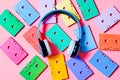 Painted audio cassettes and blue headphones on pink background, copy space, top view. Retro musical background Royalty Free Stock Photo