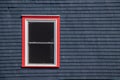 Window framed in red on a blue building Royalty Free Stock Photo