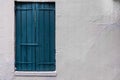 Painted blue wooden shutters and white stucco wall. Royalty Free Stock Photo