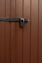 Painted brown door with a hanging iron lock outdoor Royalty Free Stock Photo