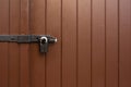 Painted brown door with a hanging iron lock outdoor. Copy space Royalty Free Stock Photo