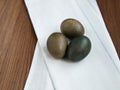 Painted chicken eggs on white material lie on brown table