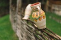 Painted clay pots or jugs on the fence. Royalty Free Stock Photo