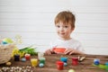 Painted and decorated eggs for Easter. Portrait of cute boy 3 years old. He holds a brush and paints Easter eggs Royalty Free Stock Photo