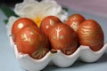 Painted Easter eggs are arranged on a decorative tray with a flower on a gray background. Close-up. Royalty Free Stock Photo