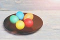 Painted easter eggs on black plate on wooden background Royalty Free Stock Photo