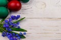 Painted Easter eggs and blue scilla flowers on white wooden background. Easter composition. Top view, copy space Royalty Free Stock Photo