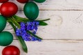 Painted Easter eggs and blue scilla flowers on white wooden background Royalty Free Stock Photo