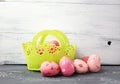 Painted Easter Eggs in decorated green basket on wooden table.