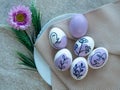 Painted Easter eggs with face and plants in purple. Royalty Free Stock Photo