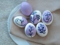 Painted Easter eggs with face and plants in purple. Royalty Free Stock Photo