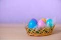 painted Easter eggs lie in basket with feathers, co Royalty Free Stock Photo